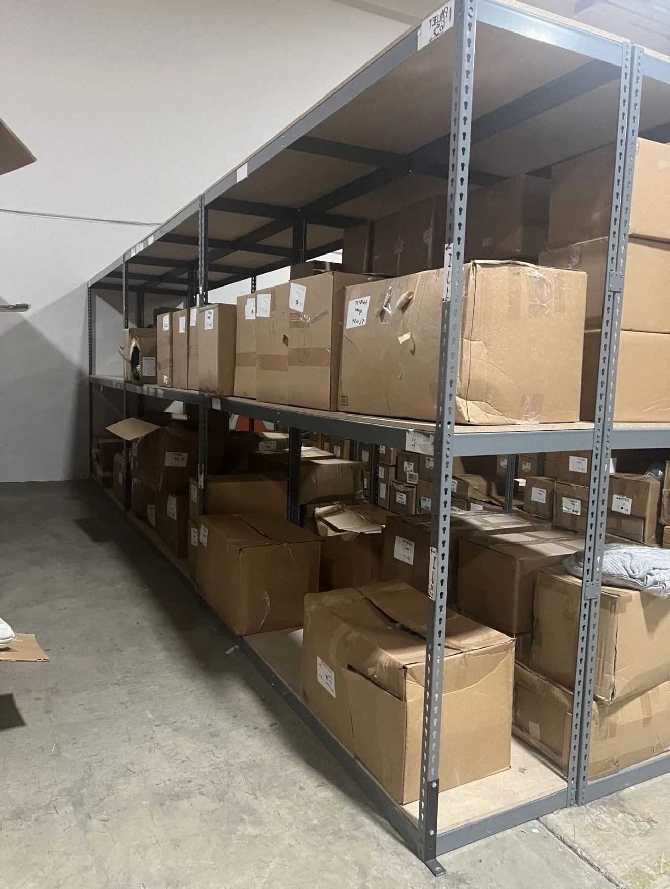 Cardboard inventory boxes stacked on warehouse shelving