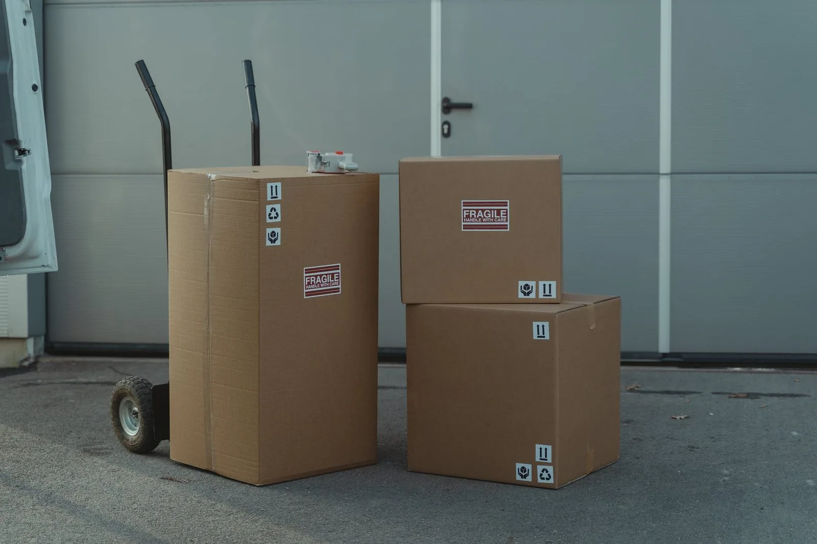 Cartons marked fragile stacked by a hand truck