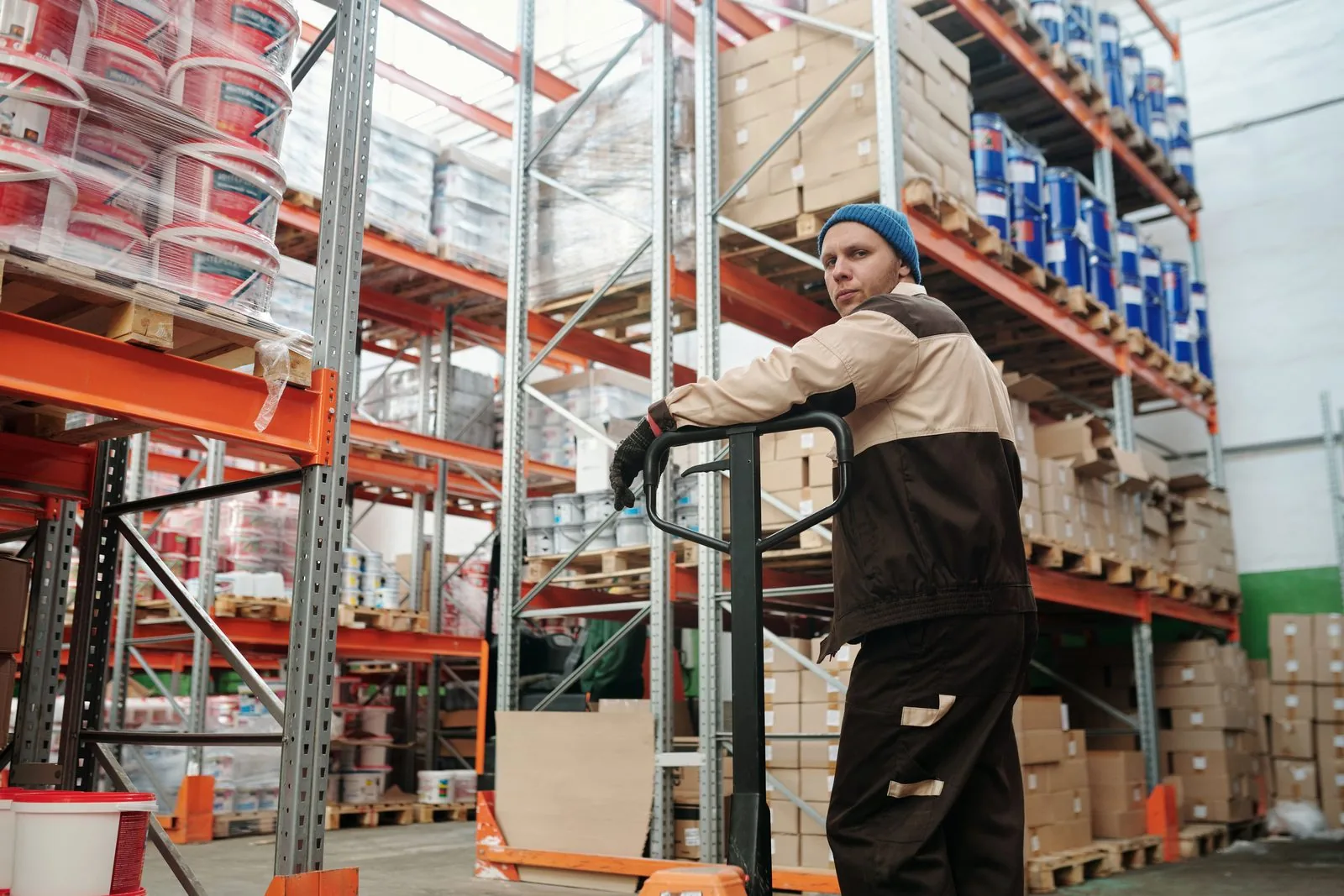 Warehouse operative moving a pallet between racking lanes