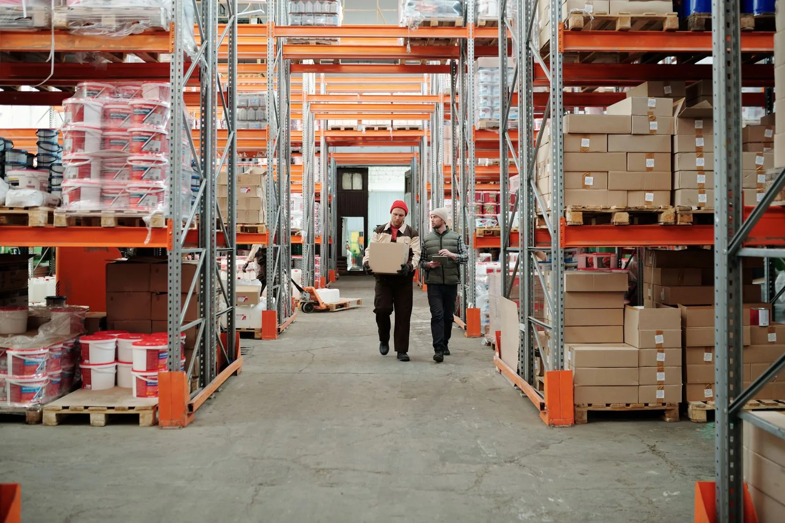 Two workers handling a package in a fulfillment warehouse