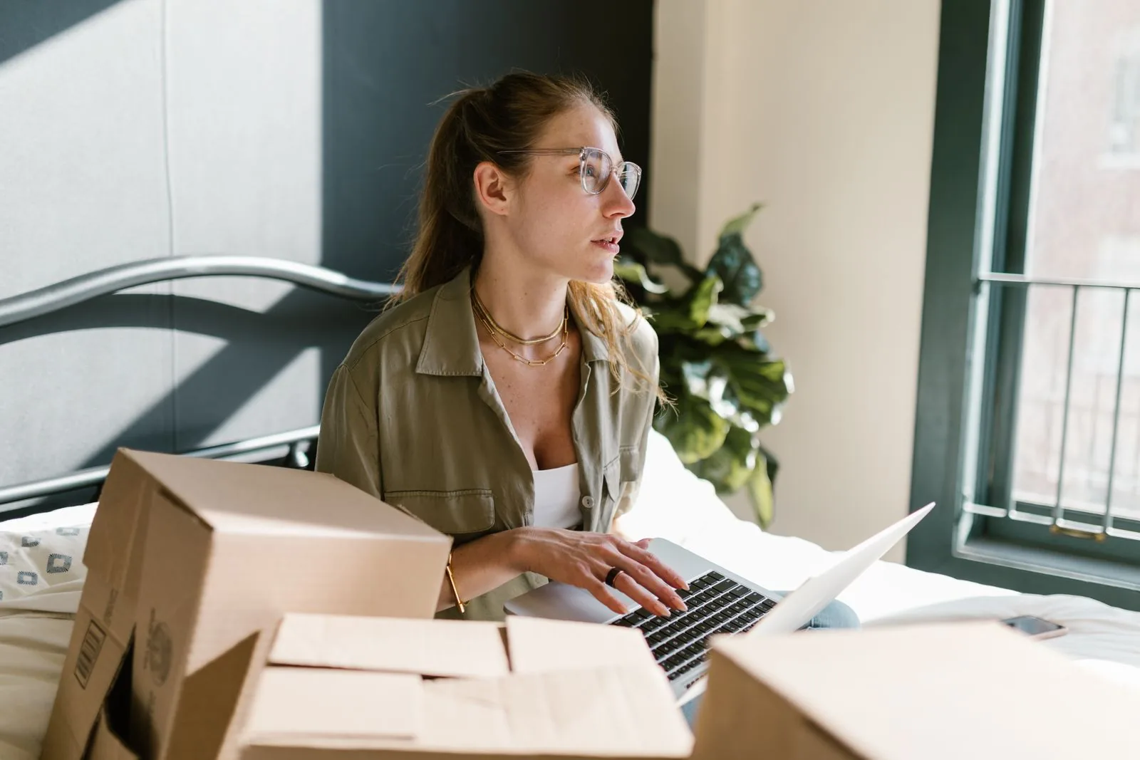 Seller managing online orders surrounded by packed boxes