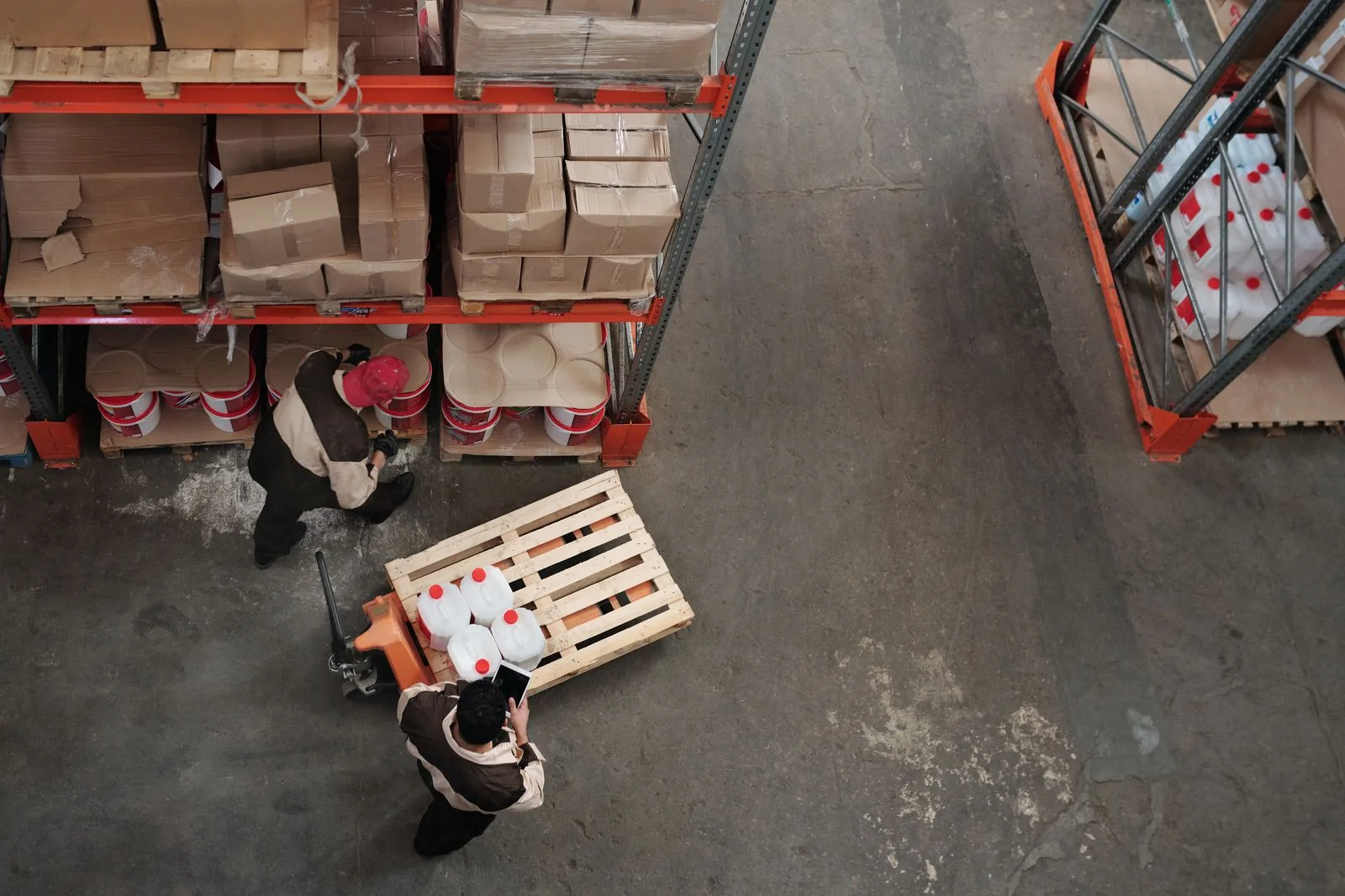 Workers organizing wholesale inventory in a warehouse